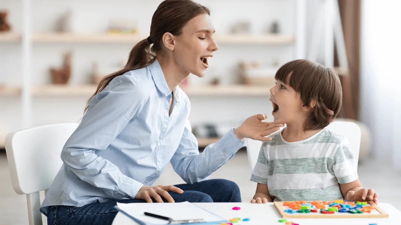 mujer profesional de la salud mental se encuentra en terapia junto a un niño