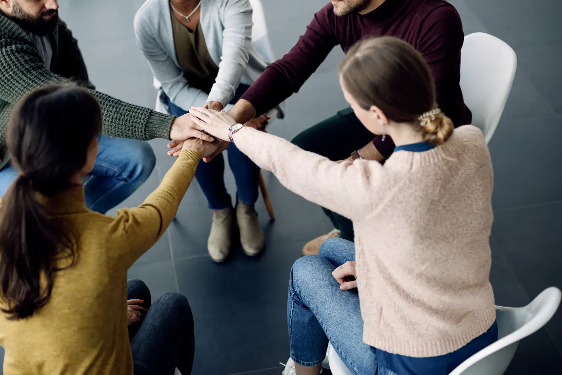 rol psicologo comunitario. Personas tomándose de las manos,