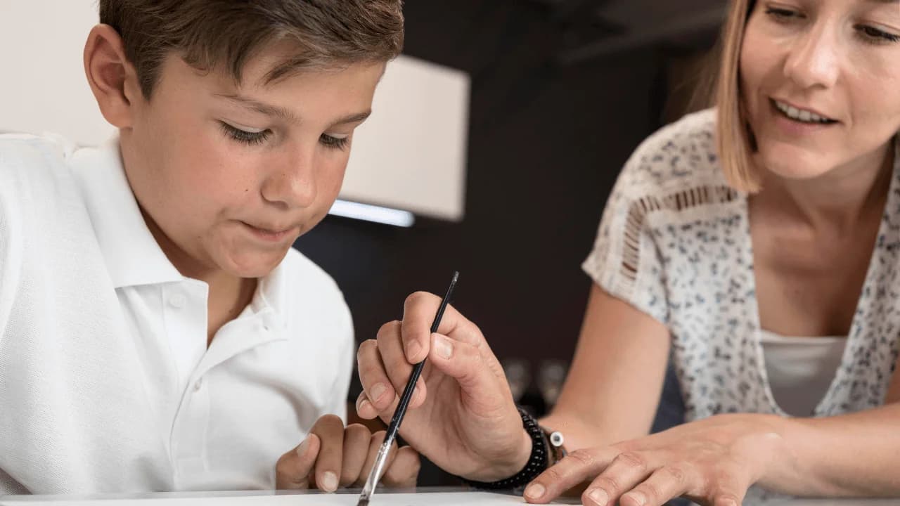 mujer ayudando a pintar a niño