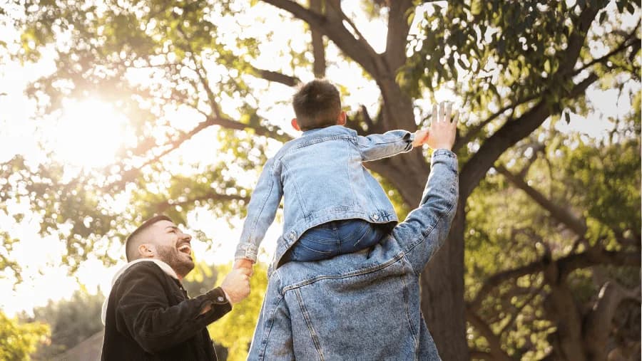 Padres jugando con su hijo en un parque, fomentando el vínculo afectivo y la parentalidad positiva