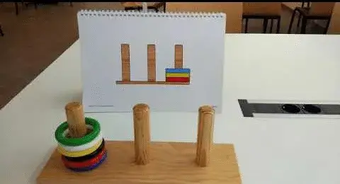 Material tipo Torre de Hanoi con anillos de colores usado para trabajar funciones ejecutivas en intervenci&oacute;n cognitiva